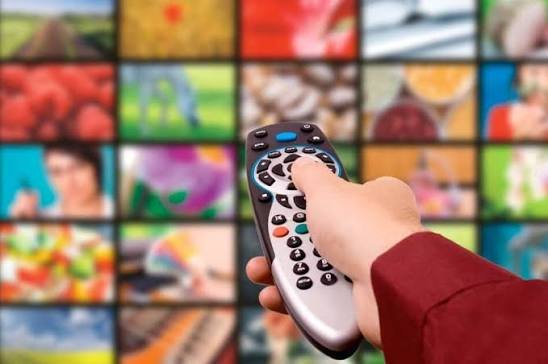 Mando a distancia frente a pantalla de televisión con múltiples canales